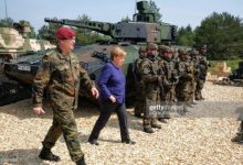 German chancellor Angela Merkel passer by a tank of the German armed forces Bundeswehr